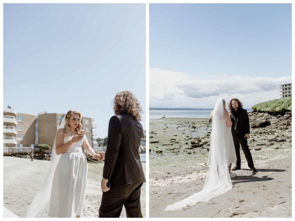 Bride and groom sharing a Ballard first look on a quiet beach before their Discovery Park wedding in Seattle, WA. The bride, in a tea-length dress and sneakers, reads her vows while holding hands with the groom, set against the serene waterfront. 