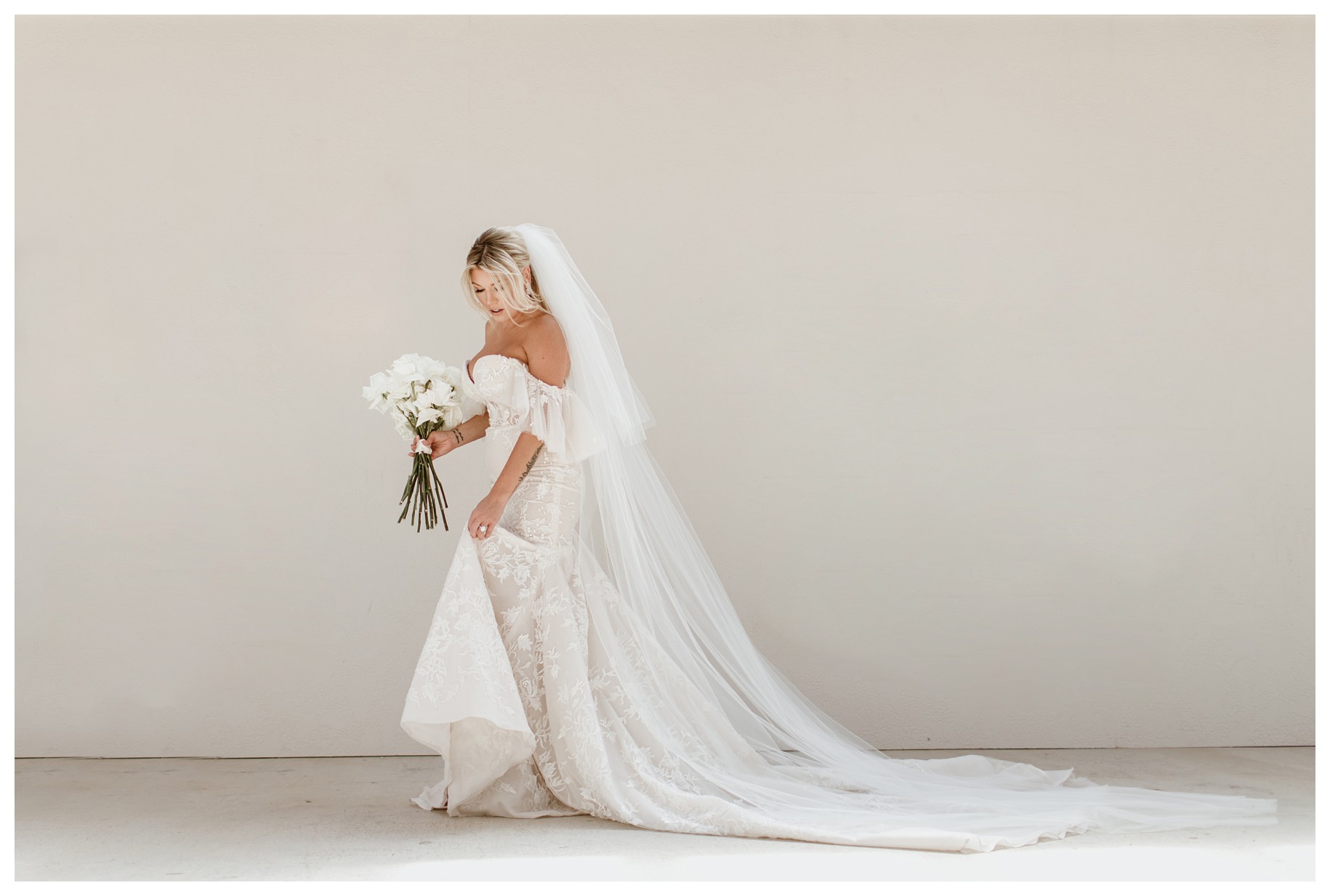 A stunning bride in her elegant lace gown and her long veil flowing behind her. Captured at Lazy S Hacienda. Looking for inspiration? Check out our guide for gorgeous getting-ready wedding photos.