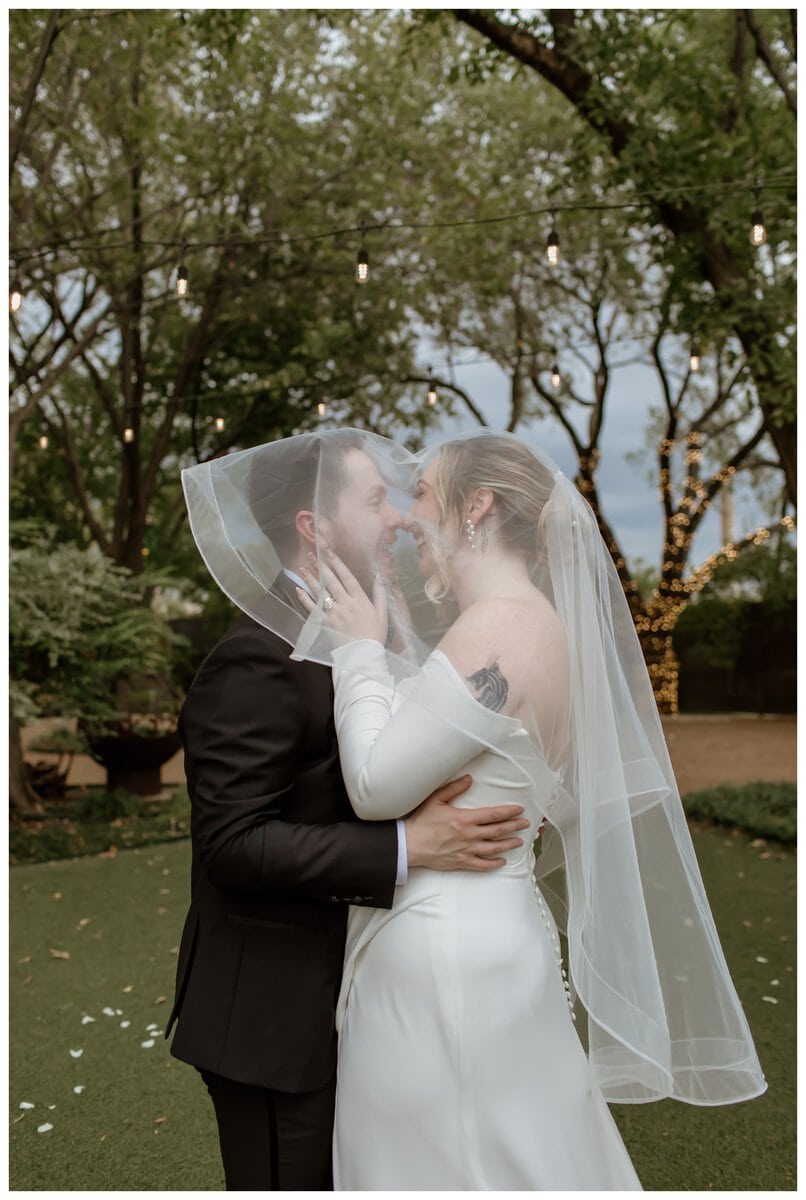 A romantic moment between a bride and groom at their Artspace111 Fort Worth wedding, as they share a joyful embrace under the bride’s veil.