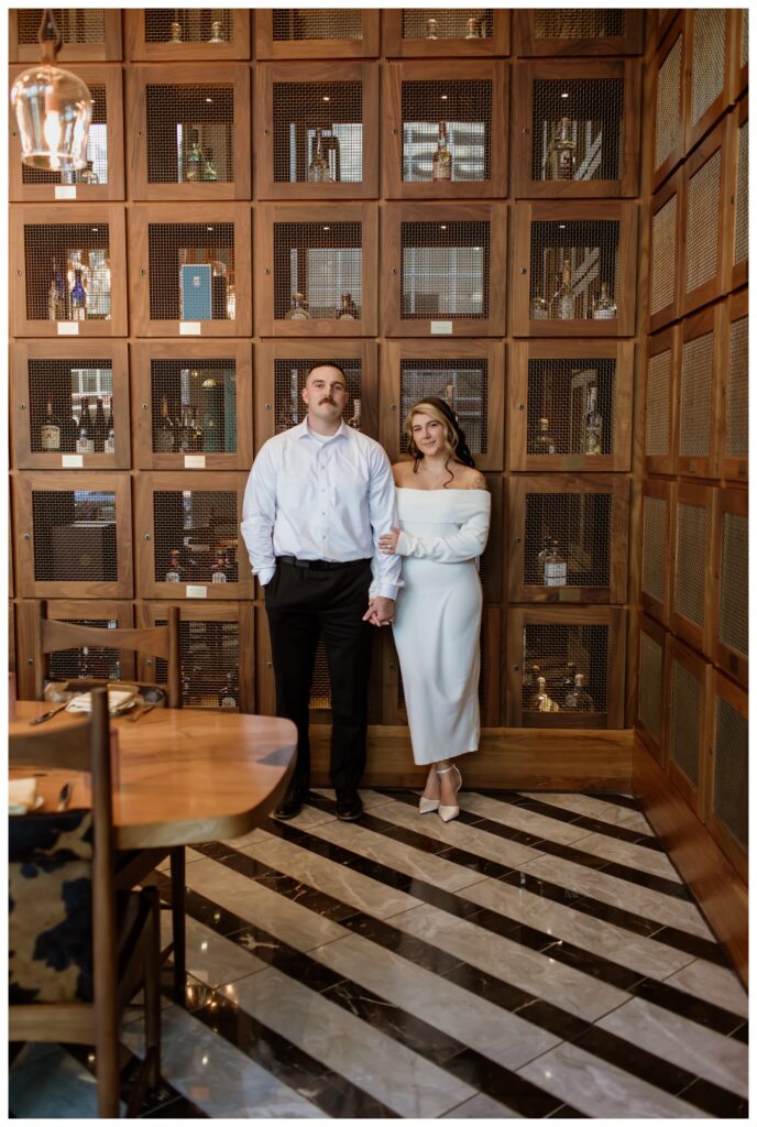 Engaged couple in a stylish downtown Fort Worth bar during their engagement photo session.