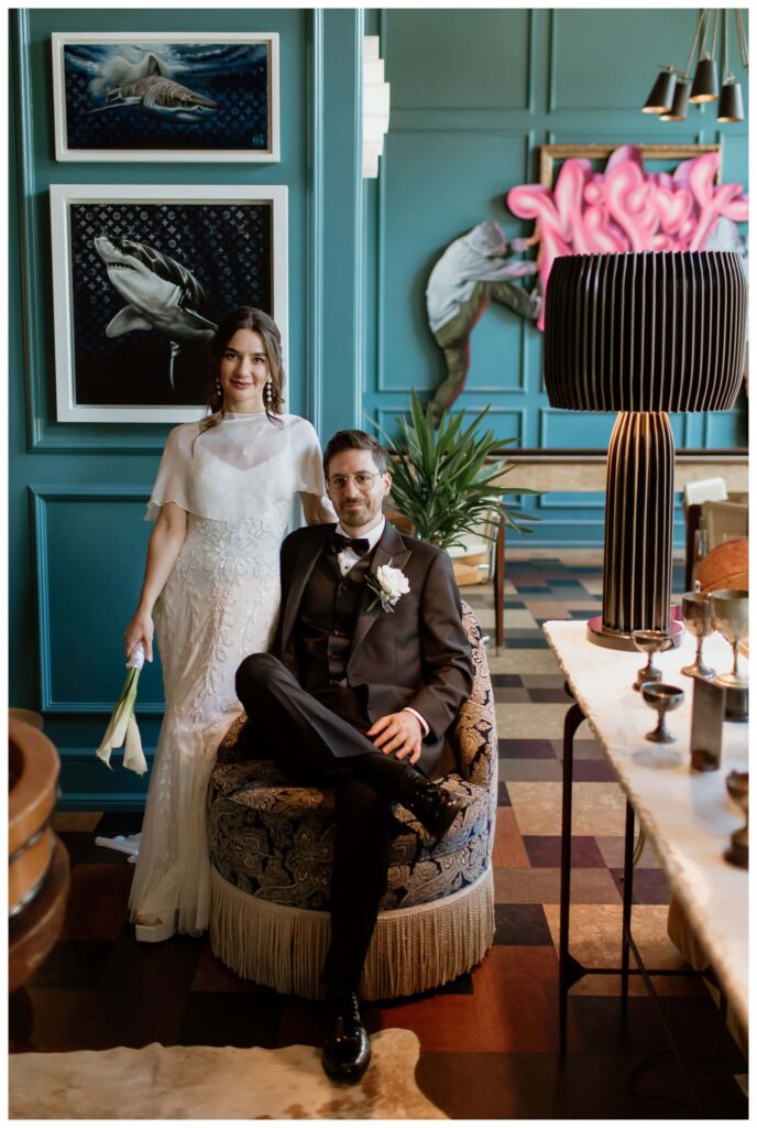 Bride and groom posing inside Bowie House during an intimate Bowie House wedding in Fort Worth, Texas, surrounded by rich teal walls, eclectic art, and modern western decor.