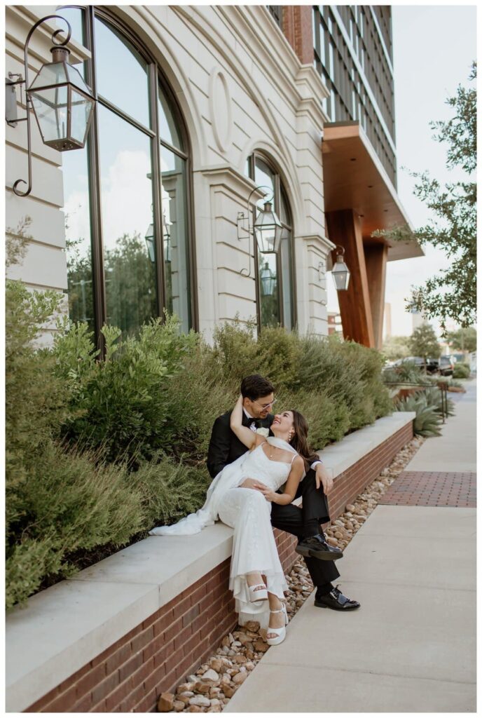 A bride and groom share a sweet, cuddly moment outside their Bowie House wedding in Fort Worth.