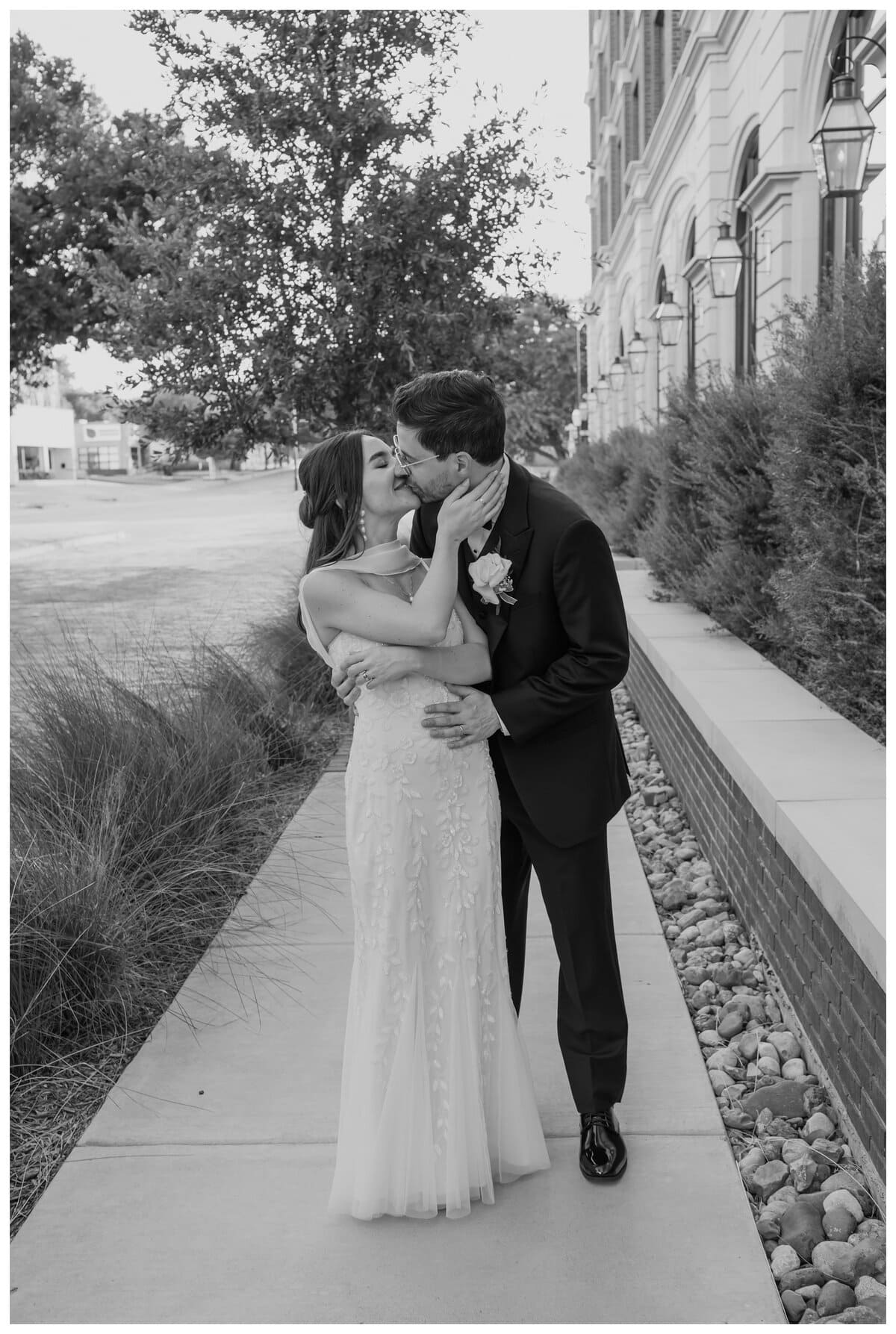A bride and groom share a sweet, intimate moment outside their Bowie House wedding in Fort Worth.